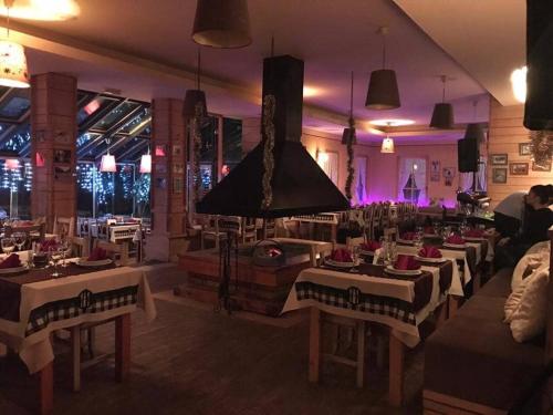 a restaurant with white tables and chairs and lights at Hotel Snjezna kuca - Nature Park of Bosnia Herzegovina in Mostar