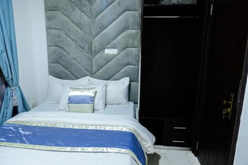 a bedroom with a bed with a large headboard at Cc & Cg Homes Luxury 4-Beds Apart Abuja-24Hrs Power in Abuja
