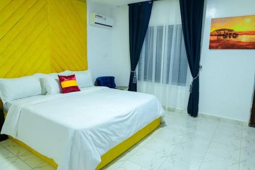 a bedroom with a white bed with a red pillow at Cc & Cg Homes Luxury 4-Beds Apart Abuja-24Hrs Power in Abuja