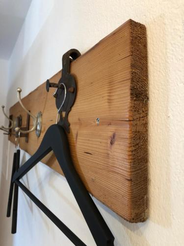a wooden board attached to a wall with a pair of scissors at Ferienwohnung Familie Zint in Sonthofen