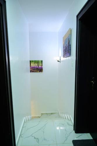 a white room with a bed and two pictures on the wall at Cc & Cg Homes Luxury 4-Beds Apart Abuja-24Hrs Power in Abuja