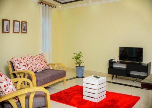 a living room with a couch and a tv at Keisha Luxury Furnished Apartment Bukoto in Kampala
