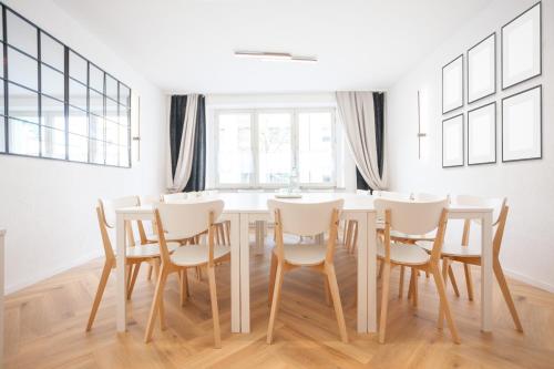uma sala de jantar branca com uma mesa e cadeiras em TM Hotel Dortmund Airport em Holzwickede