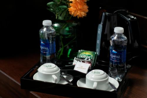 a tray with two bottles of water and tea cups at MAY DE VILLE Crown Hotel in Hanoi