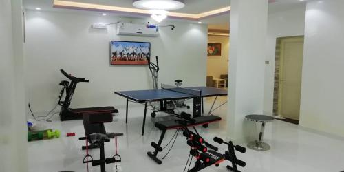 una habitación con una mesa y algunos equipos de ejercicio en Almalki furnished units, en Al Thybiyah