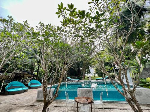 a pool at a resort with trees in the foreground at Eagleye Langkawi in Tanjung Rhu 