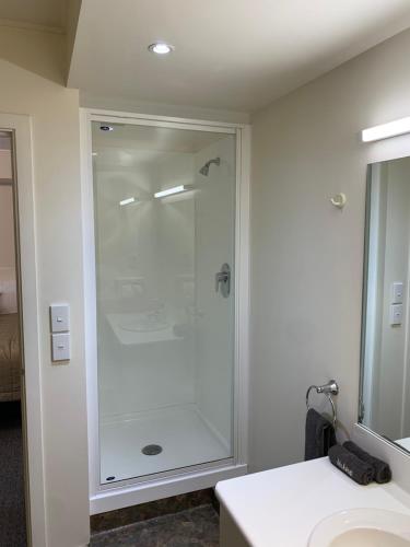 a bathroom with a shower with a glass door at 755 Regal Court Motel in Dunedin