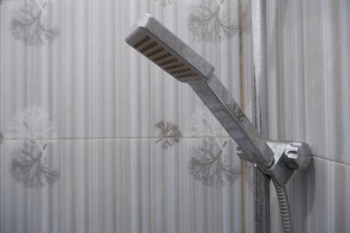a blow dryer in front of a shower curtain at Griya Limasan Gunung Kidul in Wonosari