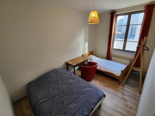 ein Schlafzimmer mit einem Bett und einem Tisch und einem Fenster in der Unterkunft Grande Maison meublée tout équipé Wifi, Télé, Billard - Demeure de 196 m2 à Tain l'hermitage - 5 Chambres - 12 Couchages in Tournon-sur-Rhône
