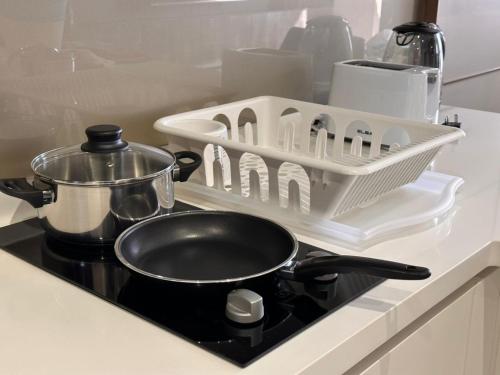 a stove top with a pot and a strainer on it at 8 Kia Peng Residences by StayHere in Kuala Lumpur