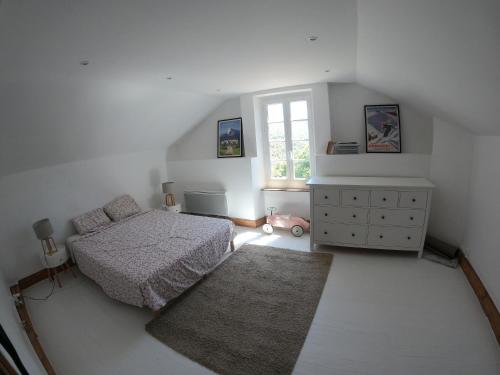 a bedroom with a bed and a dresser and a window at Faites le plein de nature ! in Arbon