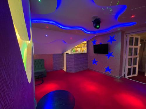 um quarto com um tapete vermelho e luzes azuis em Pearl Suites Apartments em Nakuru