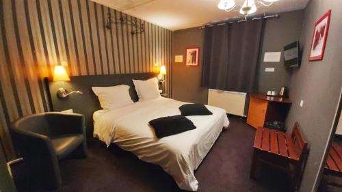 a hotel room with a bed and a chair at Hôtel 1er Consul Rouen in Rouen