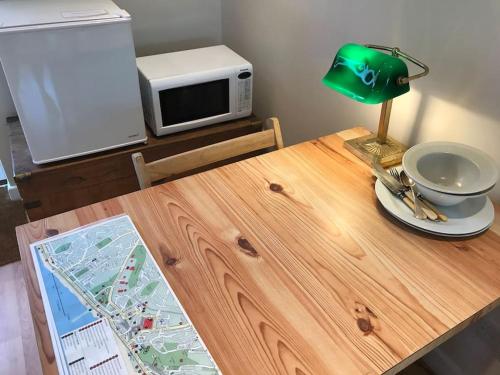 a table with a green lamp and a microwave at Apartment with own entrance & terrace on West Hill in Hastings