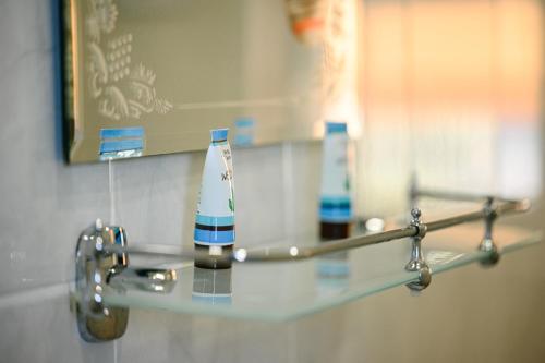 ein Glasregal in einem Badezimmer mit zwei Flaschen darauf in der Unterkunft AMAZING view, privacy and comfort - Villa Krasi in Blagoewgrad
