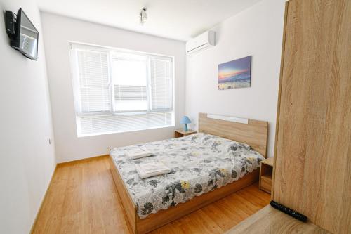 Schlafzimmer mit einem Bett und einem Fenster in der Unterkunft AMAZING view, privacy and comfort - Villa Krasi in Blagoewgrad