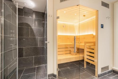 uma casa de banho com uma cabina de duche ao nível do chão e uma cabina de duche ao nível do chão em Ferienhaus Finoah - Leben, Luxus, Leichtigkeit hinter der Duene in Westerland Sylt em Westerland