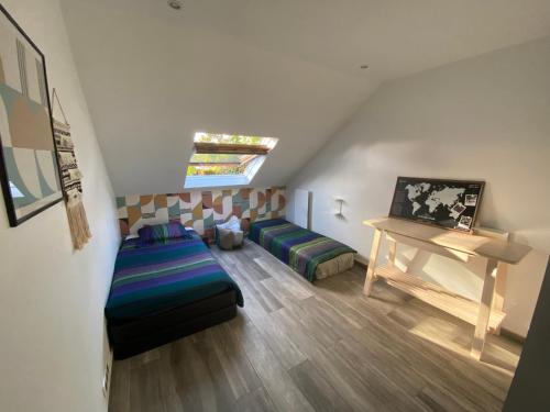 um quarto no sótão com um sofá e uma mesa em Station House - Maison entre Disneyland et Paris em Roissy-en-Brie