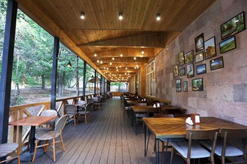 un ristorante con tavoli e sedie in legno e finestre di Park Resort Aghveran a Agveran