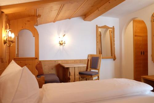 a bedroom with a bed and a desk and a mirror at Apart Auhof in See