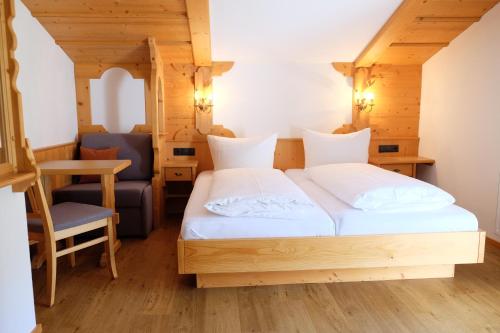 a bedroom with a bed and a desk and a chair at Apart Auhof in See