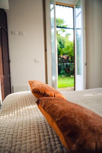 a bed with brown pillows on it with a window at Casa N in Arona