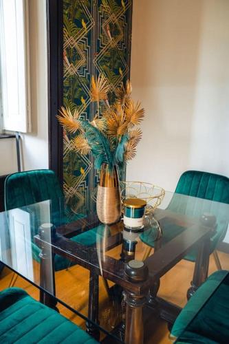 a glass table in a room with green chairs at Casa N in Arona