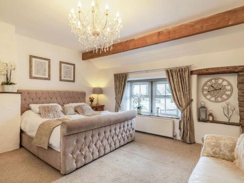 a bedroom with a large bed and a chandelier at Tynedale in Padiham