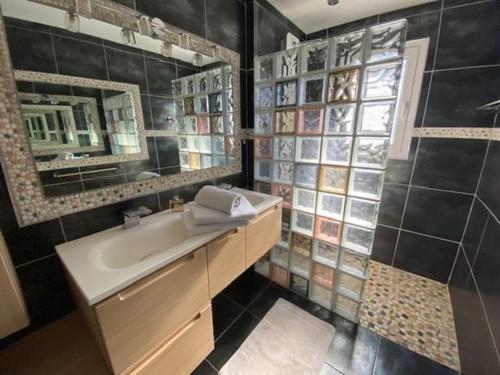 uma casa de banho com um lavatório e um espelho em Magnifique Maison Piscine Andernos sur le Bassin d'Arcachon ! em Andernos-les-Bains