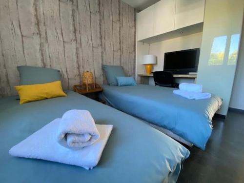 um quarto com 2 camas e toalhas em Magnifique Maison Piscine Andernos sur le Bassin d'Arcachon ! em Andernos-les-Bains