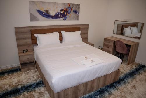 a bedroom with a large bed with white sheets at فندق المدينة القديمة Old Town Hotel in Nizwa