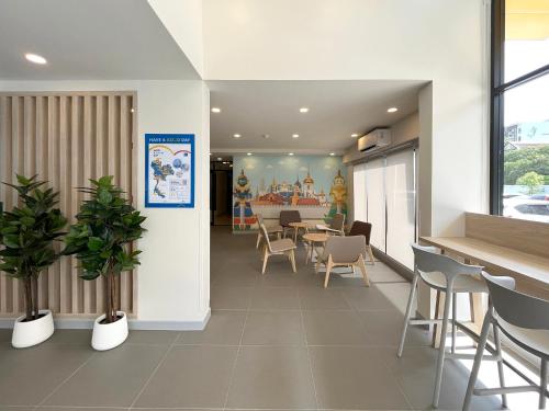 a waiting room with tables and chairs in a building at HOP INN Bangkok Onnut Station in Bangkok
