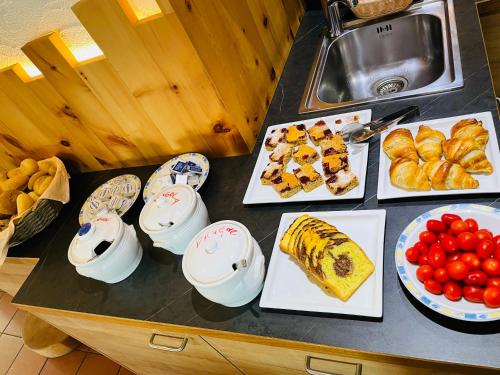 a table topped with plates of food and fruit at Hotel Elisabeth Panorama in Antermoia