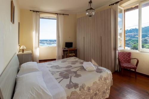 a bedroom with a bed and a chair and windows at Albergo Bandoni in Rapallo