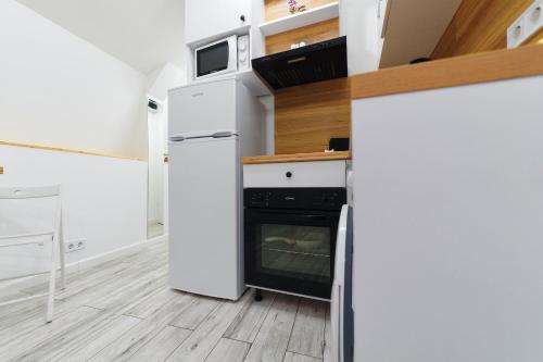 a kitchen with a refrigerator and a stove at Bella House Apartaments in Craiova
