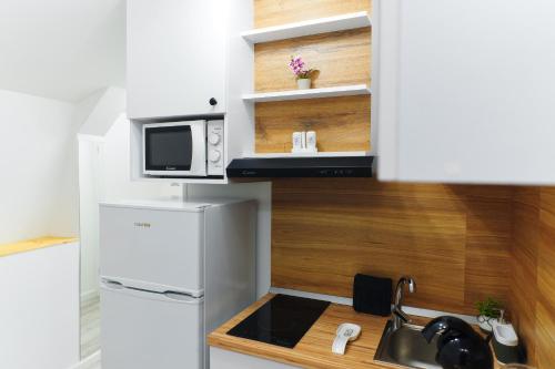 a small kitchen with a sink and a microwave at Bella House Apartaments in Craiova