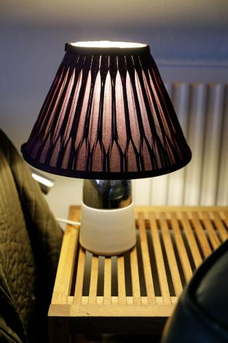 a lamp sitting on a table on a wooden table sidx sidx sidx at Lat4Rest in Prienai