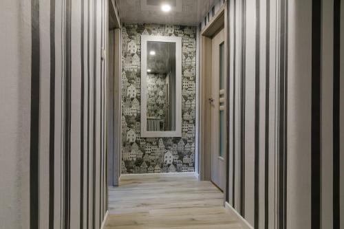 un couloir avec un miroir et un mur en briques dans l'établissement Lat4Rest, à Prienai