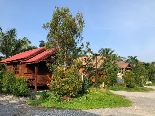 a wooden house with a red roof on a street at KOB SUK RESORT k7 , k10 in Sichon
