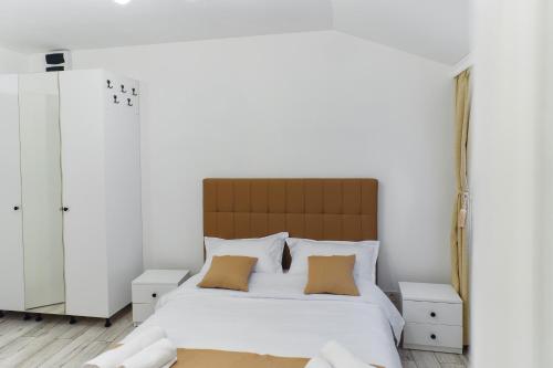 a bedroom with a large bed with white walls at Bella House Apartaments in Craiova