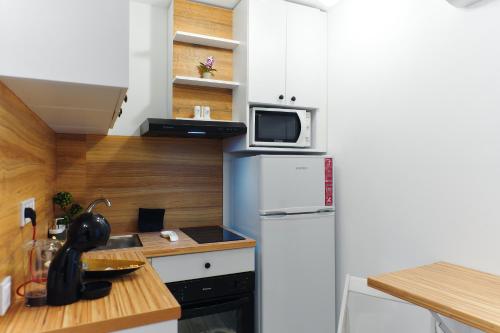 a small kitchen with a refrigerator and a microwave at Bella House Apartaments in Craiova