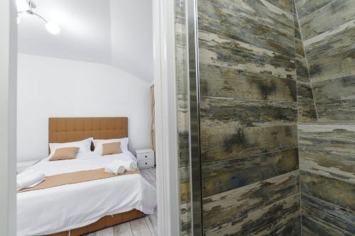 a bedroom with a bed and a glass shower at Bella House Apartaments in Craiova
