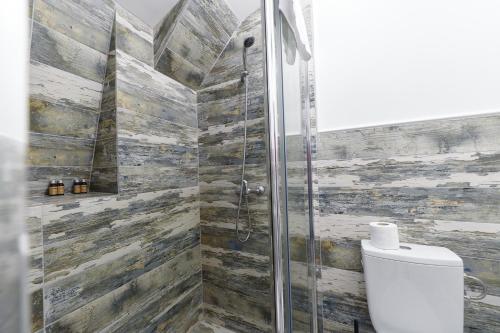 a bathroom with a toilet and a glass shower at Bella House Apartaments in Craiova
