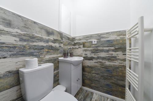 a bathroom with a toilet and a sink at Bella House Apartaments in Craiova