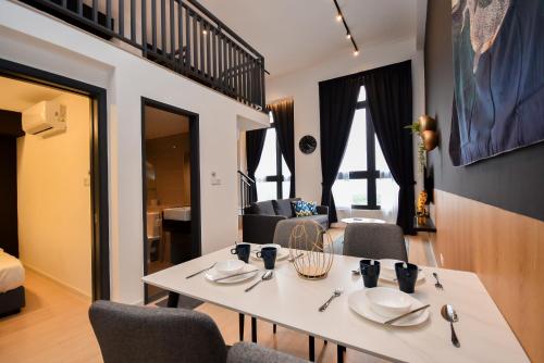 een kamer met een tafel en stoelen en een woonkamer bij Sunway Grid Loft Suite by Nest Home【Olympic Size Pool】 in Kampong Pendas