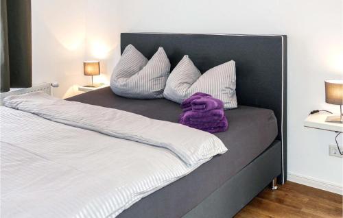 a bed with white pillows and purple blanket on it at 1 Bedroom Nice Apartment In Passow Ot Charlottenho in Zahren