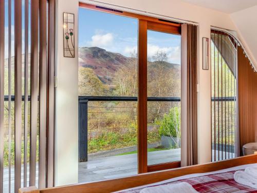 a bedroom with a window with a view of the mountains at Am Bruadar in Dalmally