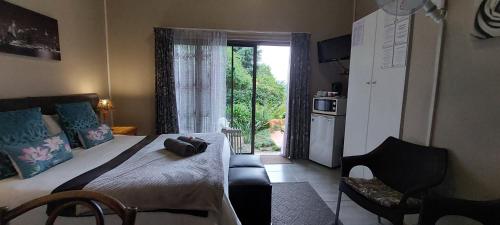 a bedroom with a bed and a kitchen with a window at King's Hill in Hilton