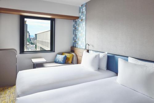 ein Hotelzimmer mit 2 Betten und einem Fenster in der Unterkunft Holiday Inn Express Osaka City Centre- Midosuji, an IHG Hotel in Osaka