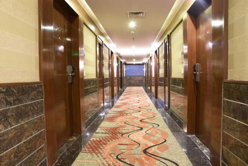 a corridor of a hotel with a carpet with a snake pattern at Souvenir Jaipur in Jaipur